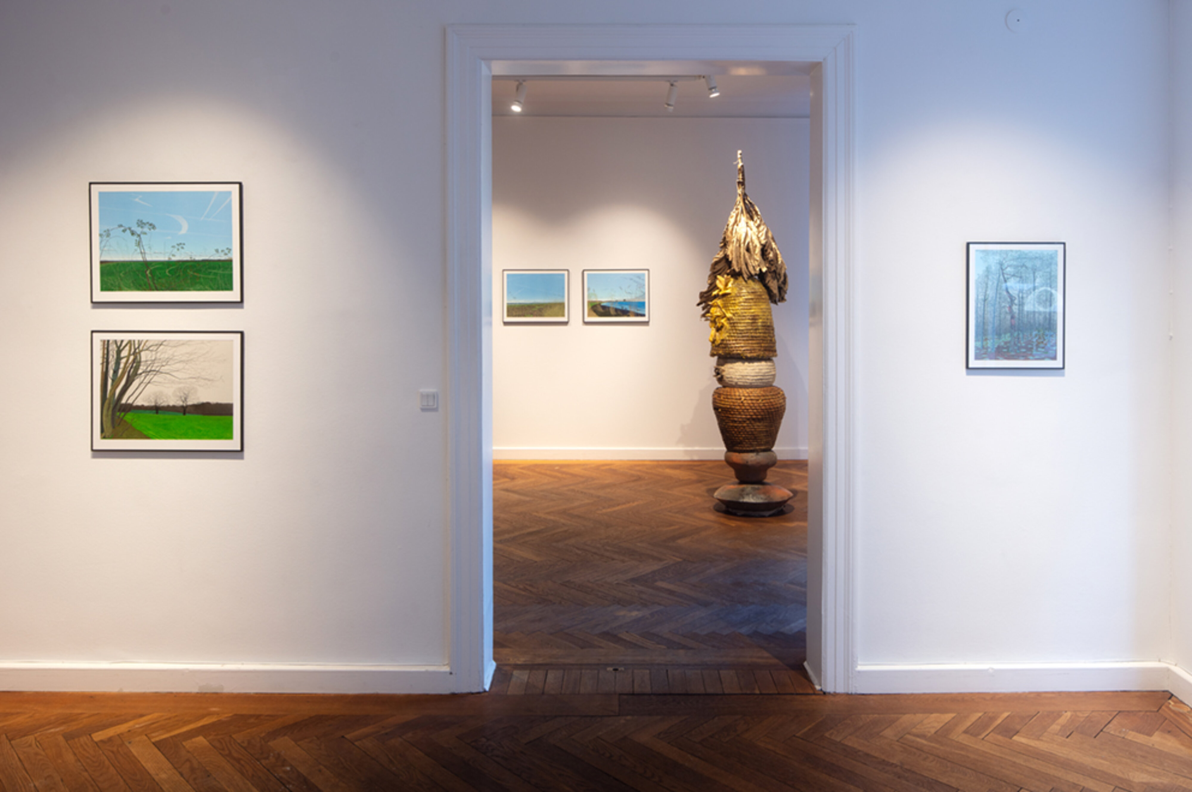 Galleriinteriør med akvarelmalerier og skulptur