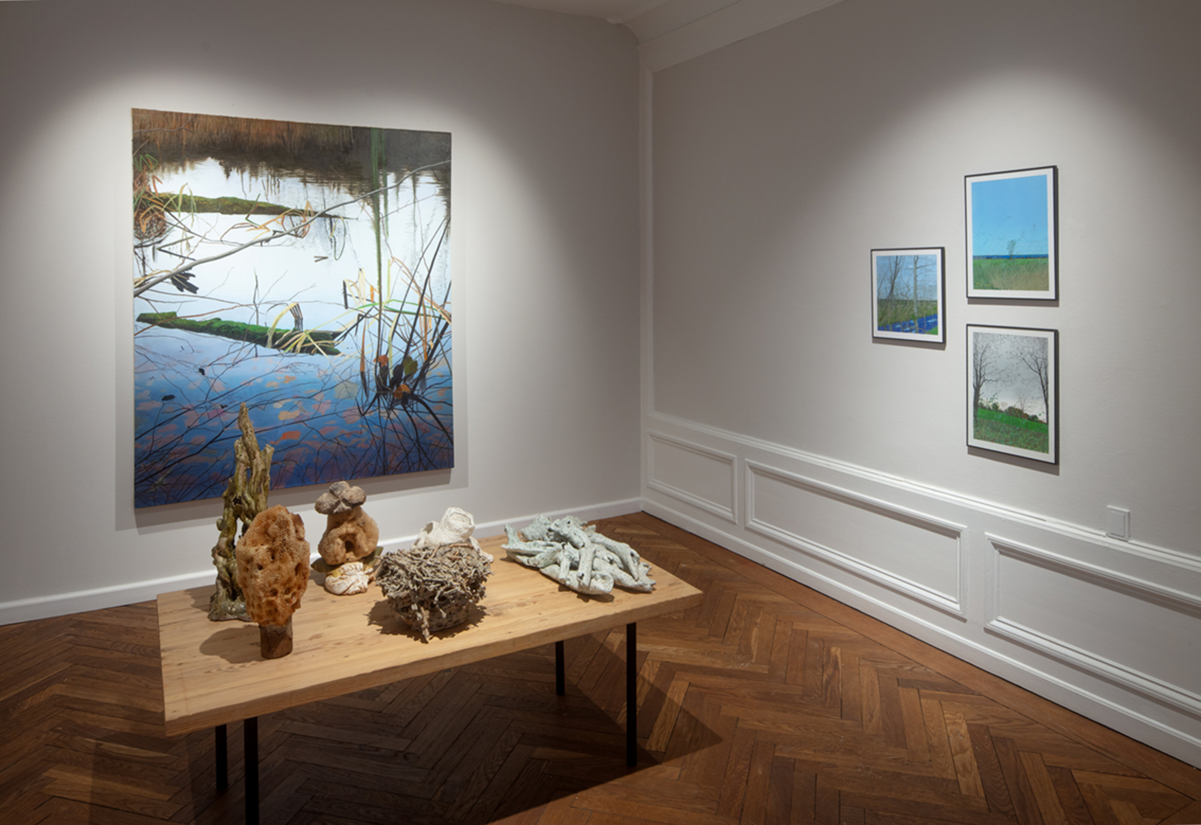 Udstillingsrum med ophængte malerier og skulpturer